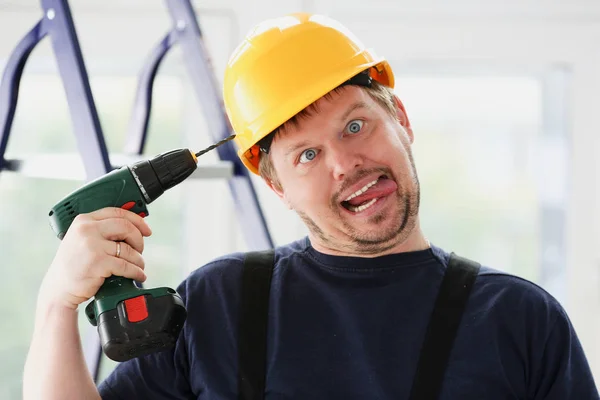 Trabalhador idiota usando retrato de broca elétrica — Fotografia de Stock