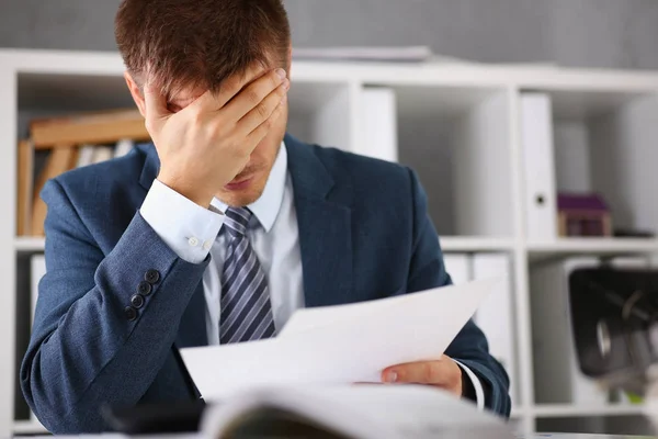 Un uomo sperimenta stress e mal di testa sul posto di lavoro — Foto Stock