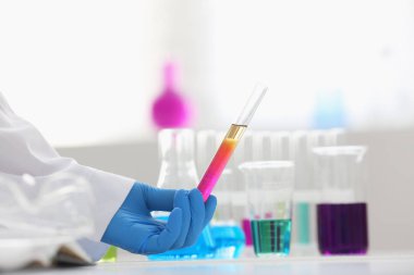 Bir erkek kimyager tüp elinde bardak sıvı bir çözüm taşmaları tutar