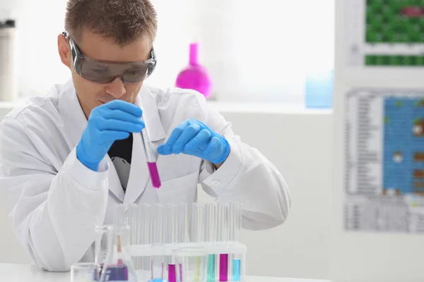 Mężczyzna chemik posiada probówki ze szkła w ręku przepełnienie roztwór — Zdjęcie stockowe