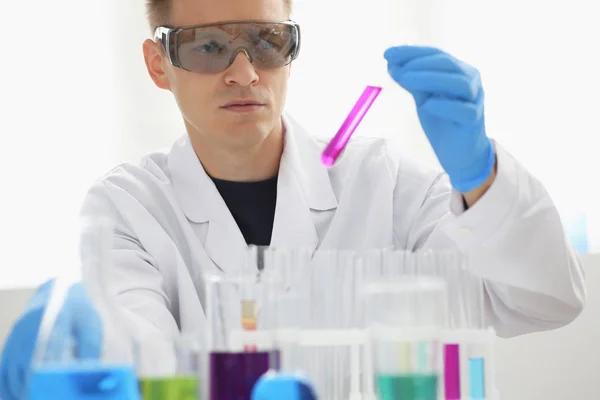 Mężczyzna chemik posiada probówki ze szkła w ręku przepełnienie roztwór — Zdjęcie stockowe