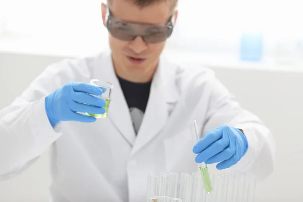 남성 화학자는 그의 손에 있는 유리의 테스트 튜브 오버플로 액체 솔루션 보유 — 스톡 사진
