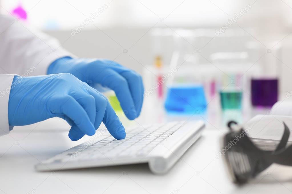 Employee chemical laboratory teacher chemist knocks his fingers keyboard