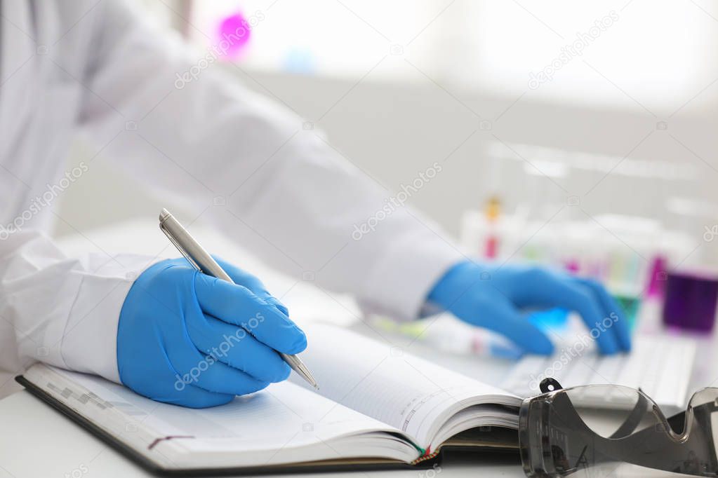 Employee of the chemical laboratory teacher chemist holds a silvery pen 