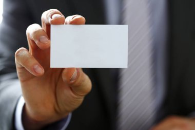 Takım elbiseli erkek kol ziyaretçiye boş arama kartı vermek
