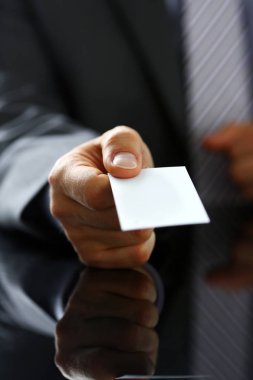 Takım elbiseli erkek kol ziyaretçiye boş arama kartı vermek