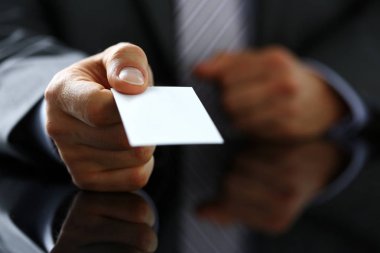 Takım elbiseli erkek kol ziyaretçiye boş arama kartı vermek