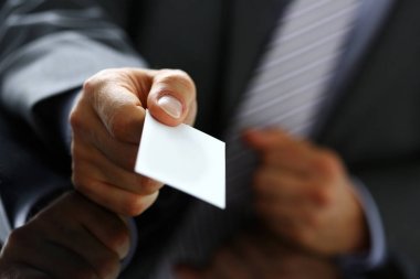 Takım elbiseli erkek kol ziyaretçiye boş arama kartı vermek