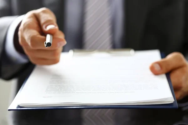 Male arm in suit offer contract form on clipboard pad