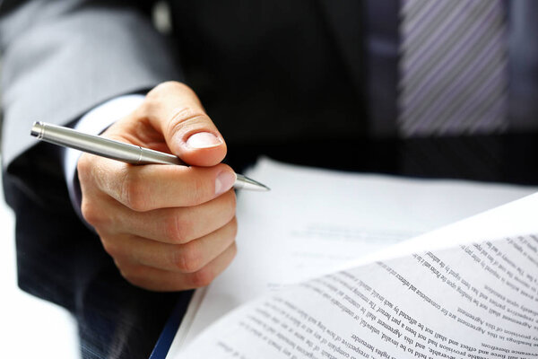 Male arm in suit and tie fill form clipped to pad