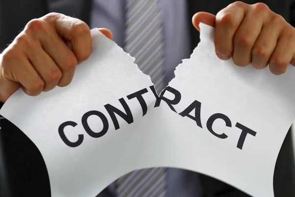 White collar worker in suit and tie tear contract