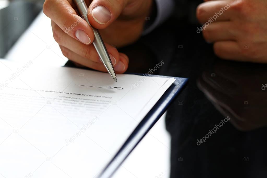 Male arm in suit and tie fill form clipped to pad