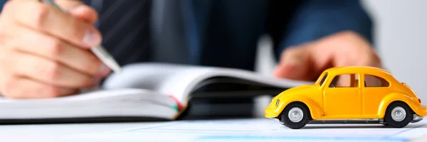 Coche de juguete amarillo irreconocible en la venta de documentos — Foto de Stock