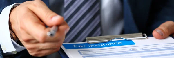 Male arm in suit offer insurance form clipped to pad — Stock Photo, Image