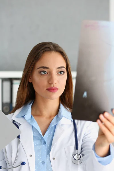 Feminino belo médico segurar na mão e olhar para xray — Fotografia de Stock