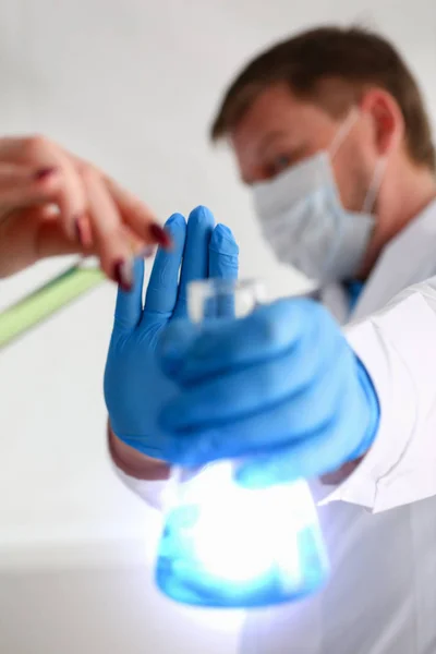Ένα αρσενικό χημικός κατέχει δοκιμαστικό σωλήνα από γυαλί με το χέρι ξεχειλίζει ένα υγρό — Φωτογραφία Αρχείου