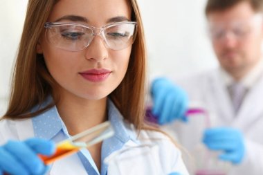 Kadın kimyacı tüp cam elinde bir sıvı taşmaları tutar