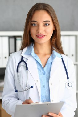 Güzel kadın doktor sit işyerinde gülümseyen.