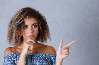 Gri bir arka plan üzerinde siyah bir kadın Puan bir parmak havada