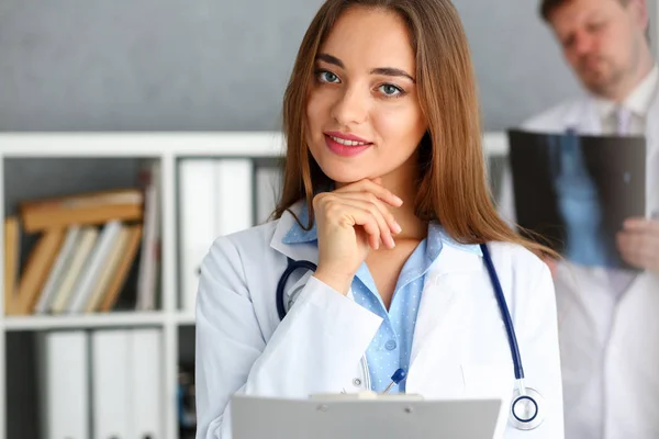 Krásný ženský lékař držet v ruce pad — Stock fotografie