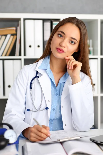 Ärztin hält silbernen Stift und Block im Arm — Stockfoto