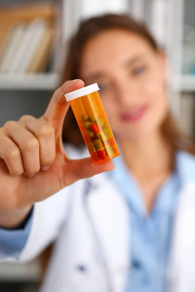 Красивая женщина-врач держит в руках бутылку с таблетками — стоковое фото