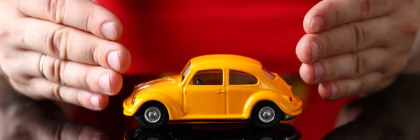 Brazo masculino en cubierta coche de juguete amarillo — Foto de Stock