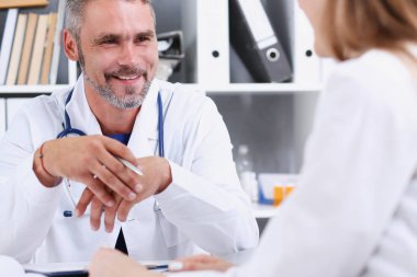 Yakışıklı olgun doktor gülümseyen hasta ile iletişim