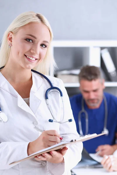 Krásný, usmívající se ženský lékař držet schránky podložka — Stock fotografie