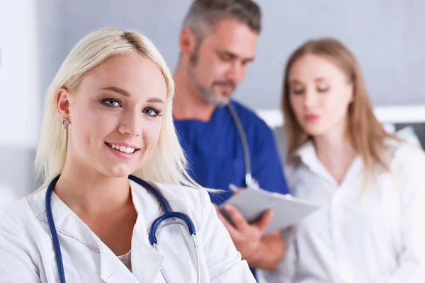 Grupo de médicos posando orgullosamente en fila y mirando a la cámara —  Fotos de Stock