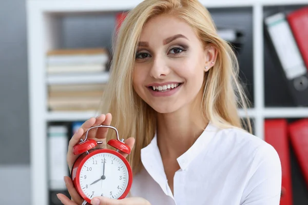 Glimlachende zakenvrouw in de hand houden van de klok — Stockfoto