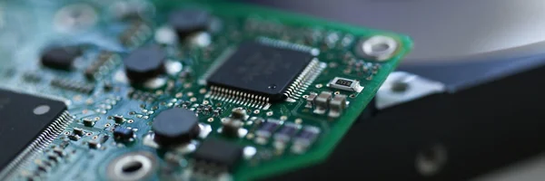 Tablero electrónico con microchips sobre un fondo de disco duro — Foto de Stock