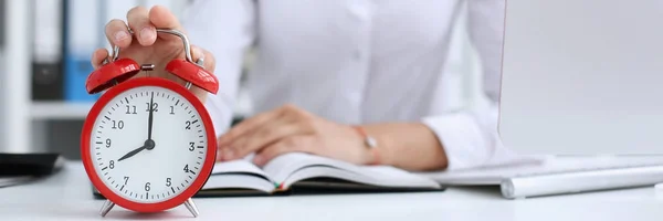 Mujer de negocios sonriente sosteniendo en reloj de mano — Foto de Stock