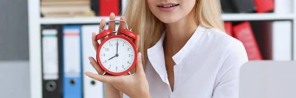 Mujer de negocios sonriente sosteniendo en reloj de mano — Foto de Stock
