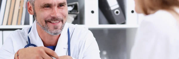 Sonriente guapo médico maduro comunicarse con el paciente —  Fotos de Stock