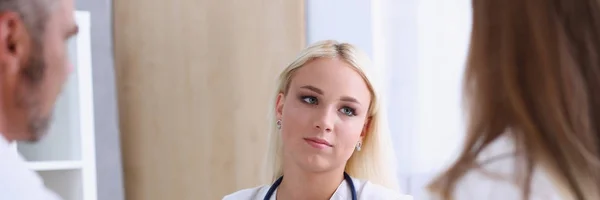 Kvinnliga läkare lyssna noga ungt par — Stockfoto