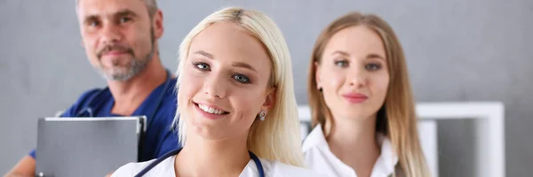 Group of medics proudly posing in row and looking in camera — Stock Photo, Image