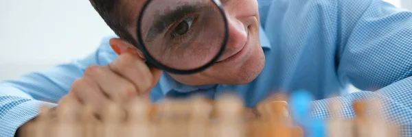 Uomo d'affari in camicia blu sta tenendo una lente d'ingrandimento nella sua h — Foto Stock