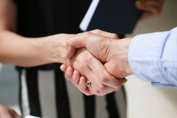 Businessman and woman shake hands as hello