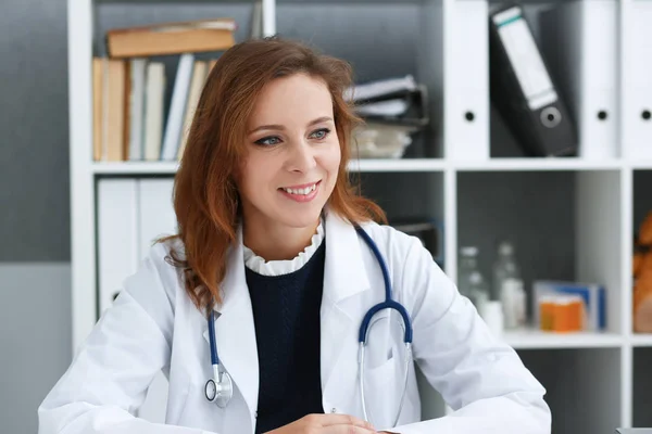 Schöne lächelnde Ärztin sitzen — Stockfoto