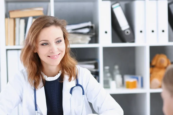 Bonita sorridente feminino médico sentar — Fotografia de Stock