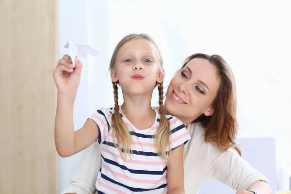 Blondes lächelndes kleines Mädchen bastelt Papierflieger — Stockfoto