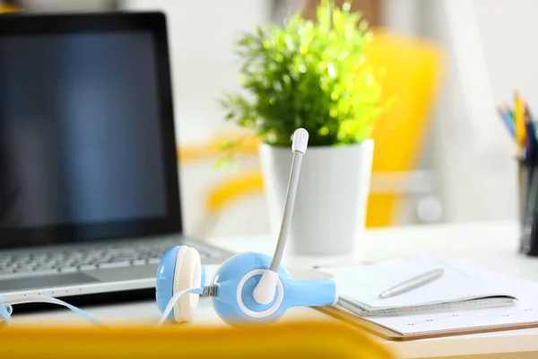 Empty remote office workplace with laptop and headset