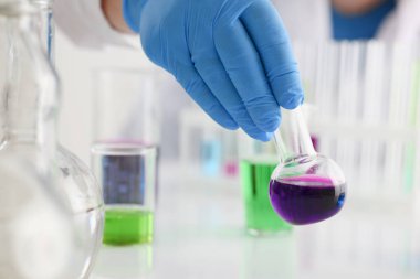 Bir erkek kimyager tüp cam tutar