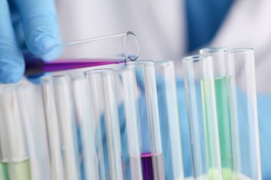 Bir erkek kimyager tüp cam tutar