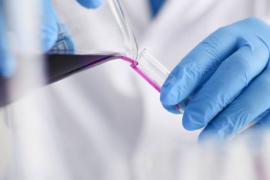 Bir erkek kimyager tüp cam tutar