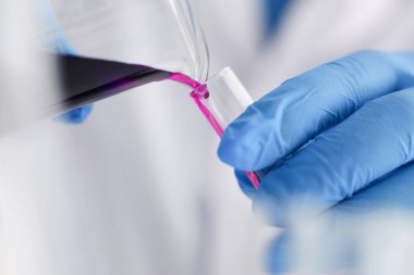 Bir erkek kimyager tüp cam tutar