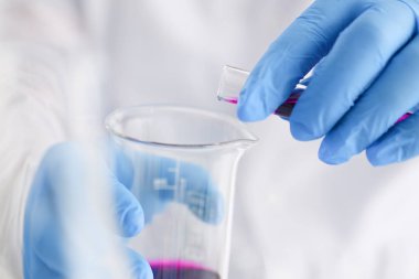 Bir erkek kimyager tüp cam tutar