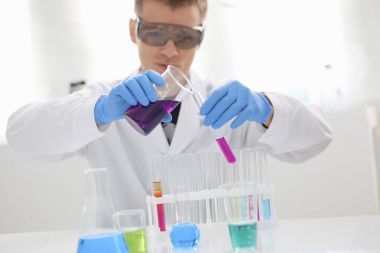 Bir erkek kimyager tüp cam tutar