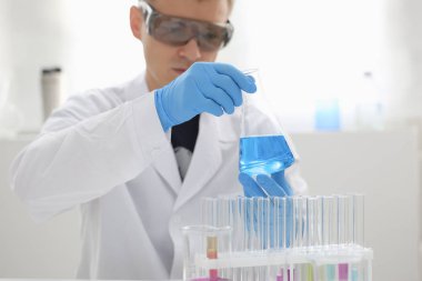 Bir erkek kimyager tüp cam tutar